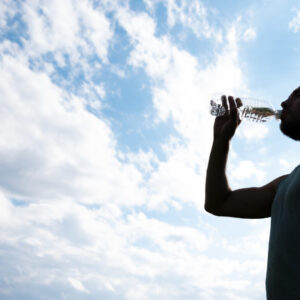 Mann trinkt aus Wasserflasche.