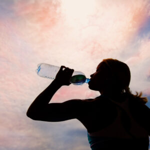 Frau trinkt aus Wasserflasche.