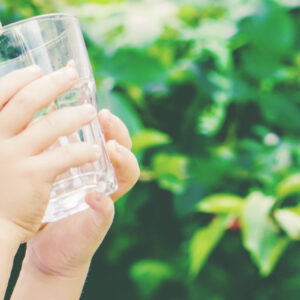 Kind trinkt aus Wasserglas.