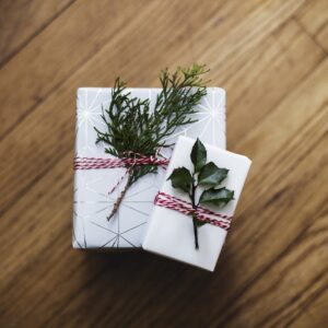 Zwei Weihnachtsgeschenke mit kleinen Zweigen dekoriert.